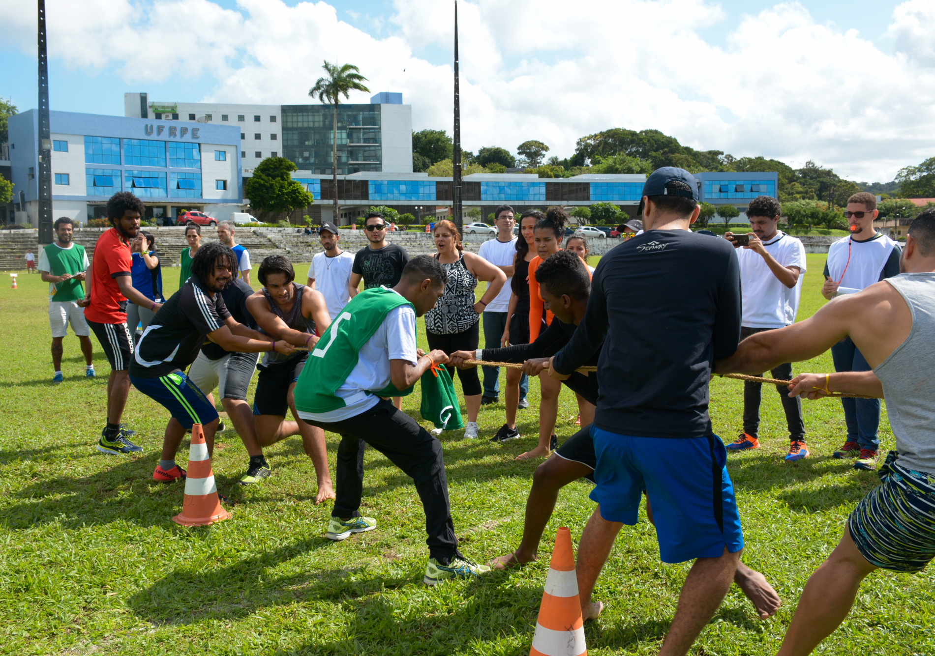 Dois grupos fazendo cabo de guerra. Prédio da UFRPE ao fundo