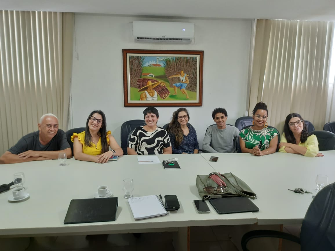 Membros da comissão em mesa de reunião 