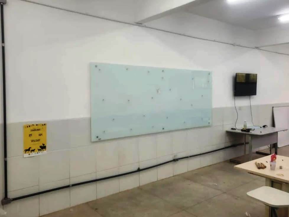 quadro de vidro instalado ao lado de tv na sala de aula