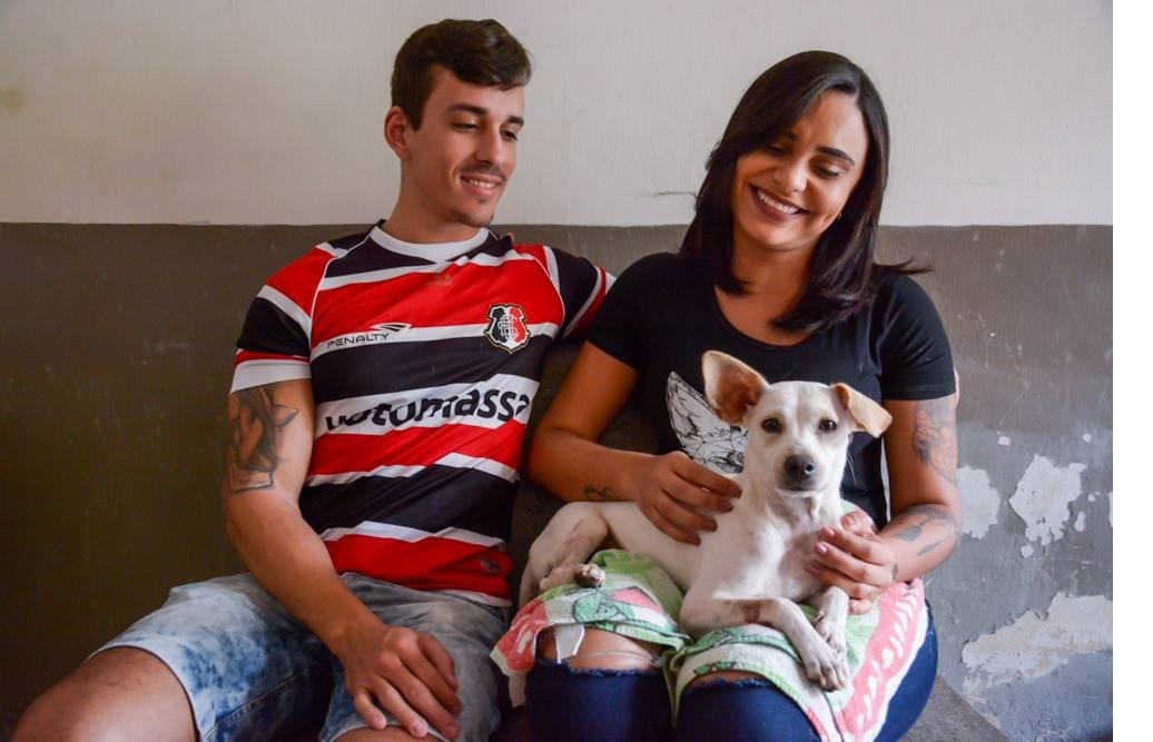 Casal tutor com animal de estimação ao colo