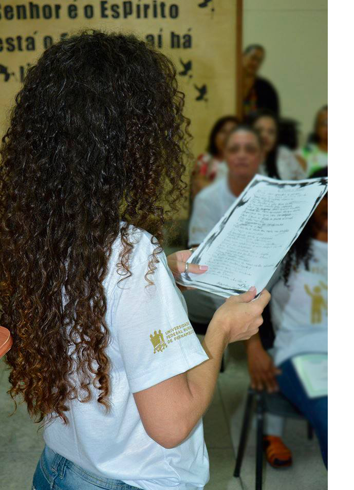 aluna do curso lendo texto para o resto da turma