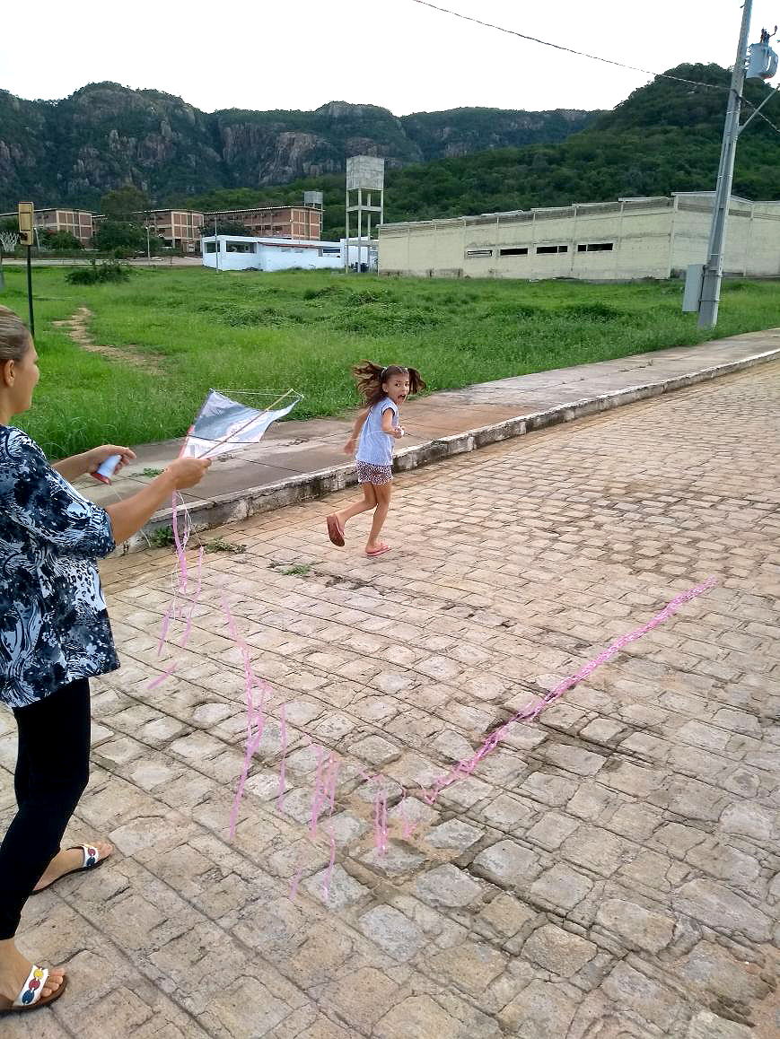 garotinha corre empinando sua pipa