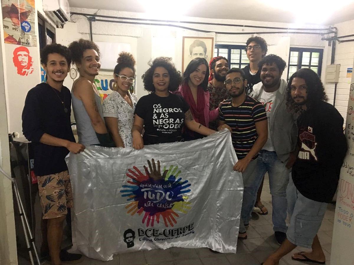integrantes do diretório central dos estudantes posam para foto segurando bandeira